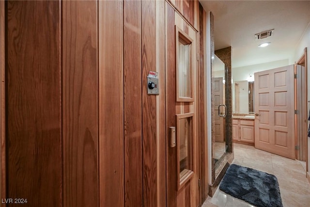 hallway featuring light tile patterned floors and visible vents