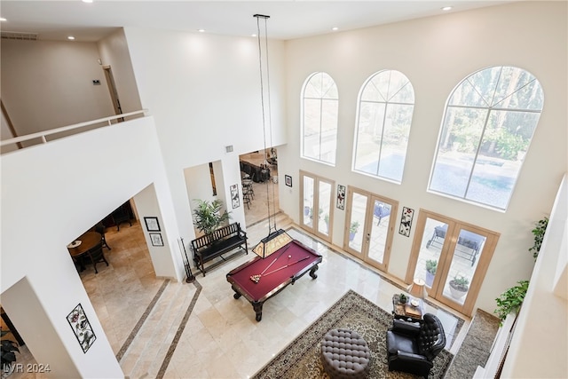 living room with light tile patterned floors and a high ceiling