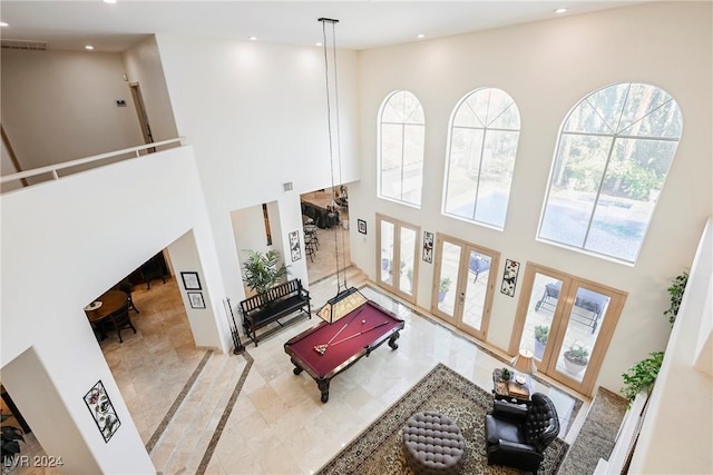 living room featuring recessed lighting, french doors, visible vents, and a towering ceiling