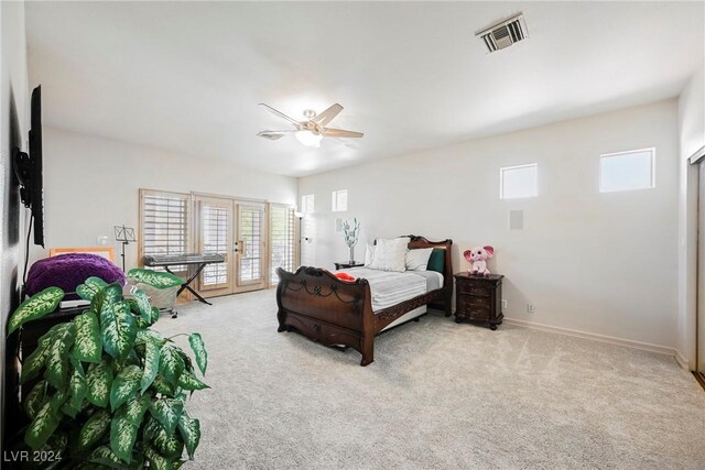 bedroom with ceiling fan, light carpet, and multiple windows