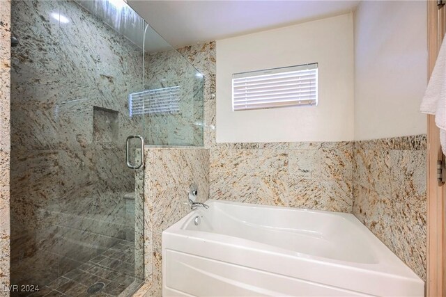 bathroom featuring separate shower and tub