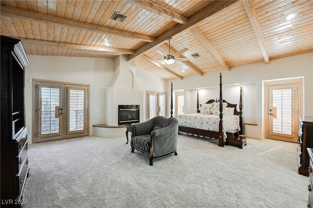 carpeted bedroom featuring multiple windows, wood ceiling, a fireplace, and beamed ceiling