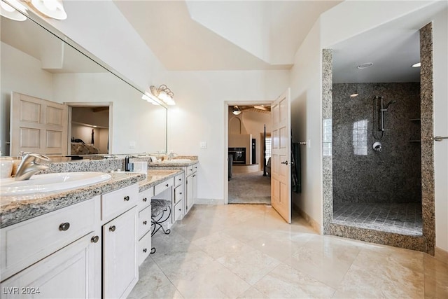 full bathroom with double vanity, baseboards, marble finish floor, walk in shower, and a sink