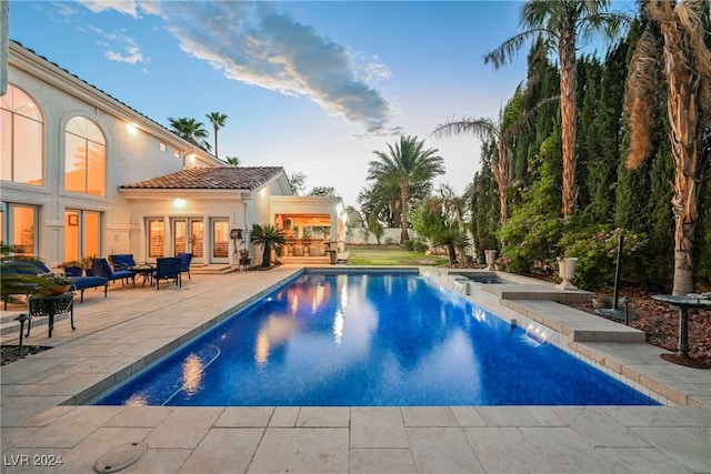 outdoor pool with a patio and french doors