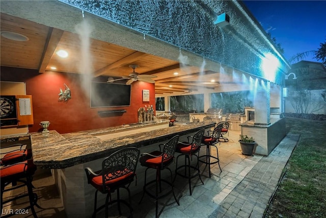 bar with indoor bar, beamed ceiling, wood ceiling, and stone tile floors