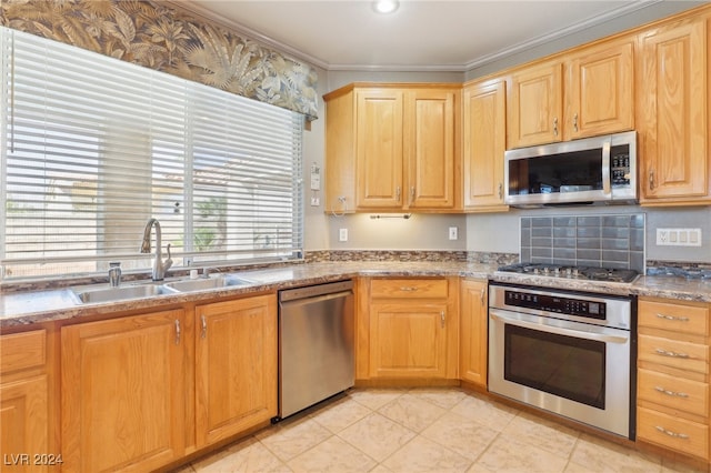 kitchen with light stone counters, sink, light brown cabinets, appliances with stainless steel finishes, and ornamental molding