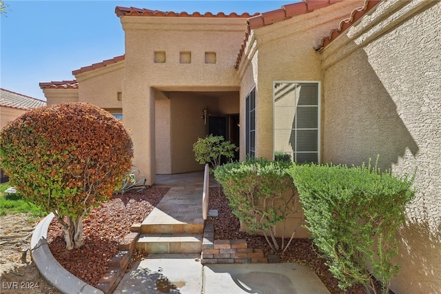 view of exterior entry with a patio