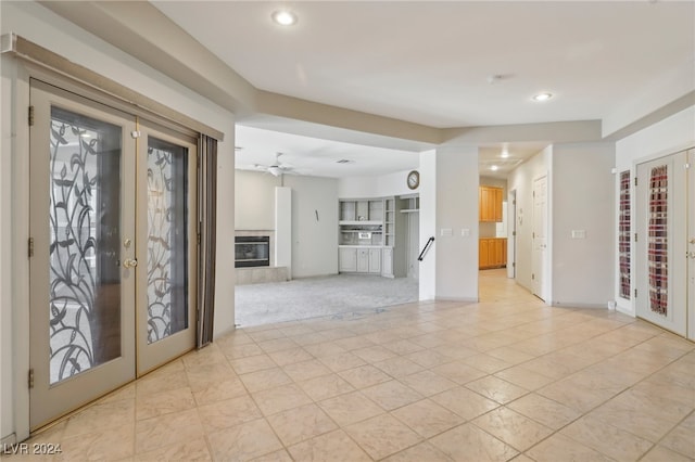 interior space with light tile patterned floors, ceiling fan, and french doors