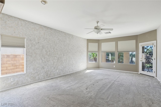 carpeted spare room featuring ceiling fan