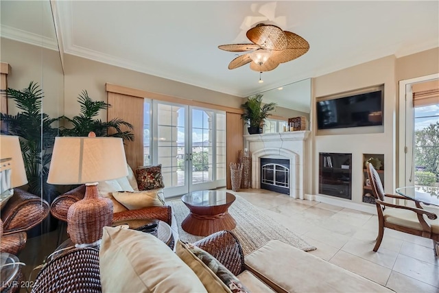 living area featuring a ceiling fan, ornamental molding, tile patterned flooring, and a fireplace
