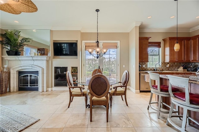 dining room featuring a chandelier, a glass covered fireplace, light tile patterned floors, baseboards, and ornamental molding