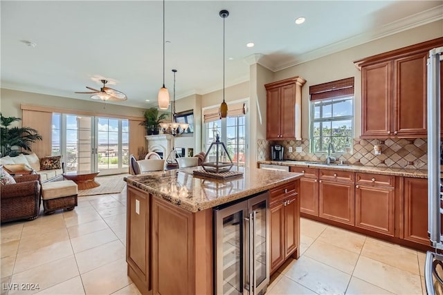 kitchen with tasteful backsplash, light stone countertops, open floor plan, beverage cooler, and brown cabinetry