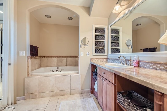 bathroom with tile patterned floors, vanity, and a bath