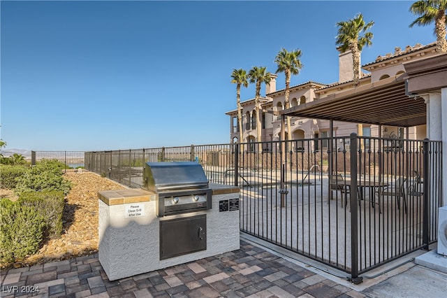 view of patio / terrace with a grill, exterior kitchen, and fence