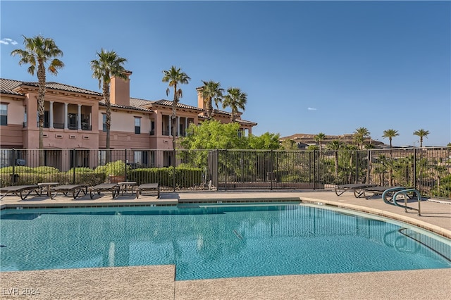 community pool with fence and a patio