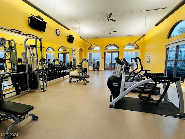 workout area featuring a high ceiling, a ceiling fan, and french doors