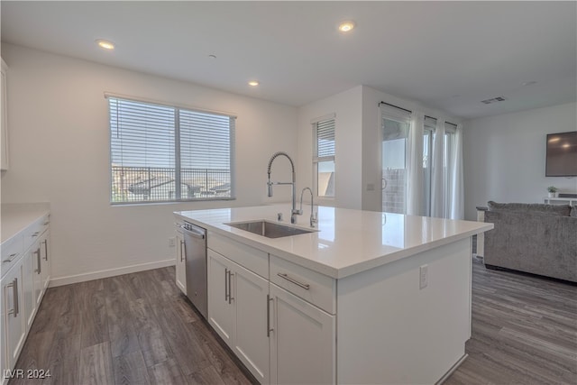 kitchen with a kitchen island with sink, sink, stainless steel dishwasher, dark hardwood / wood-style floors, and white cabinetry