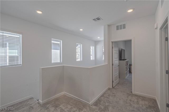 hallway featuring light colored carpet