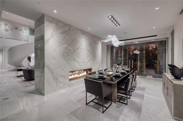 dining space with stone wall, a premium fireplace, recessed lighting, and an accent wall