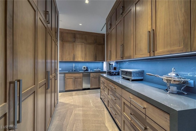 kitchen featuring dishwasher, backsplash, and a sink