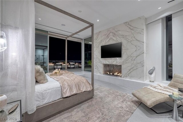 bedroom featuring expansive windows and a fireplace