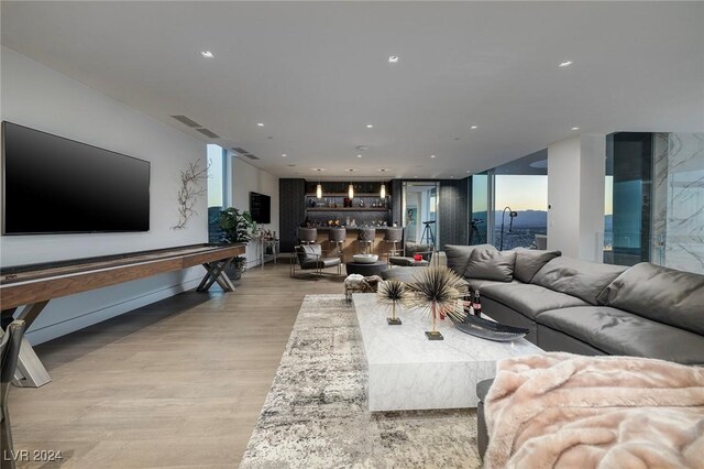 living room featuring bar and light hardwood / wood-style floors