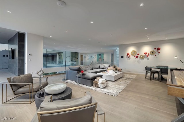 living room with light wood-type flooring and recessed lighting