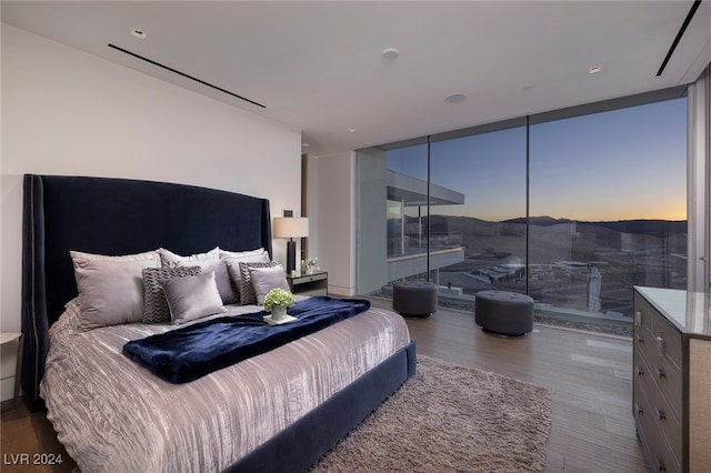 bedroom with light hardwood / wood-style floors and expansive windows