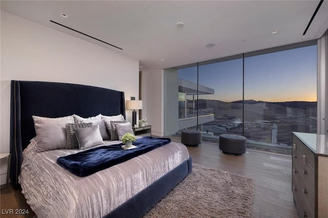 bedroom with expansive windows and wood finished floors