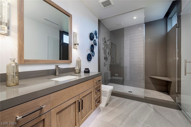 bathroom featuring toilet, vanity, and tiled shower