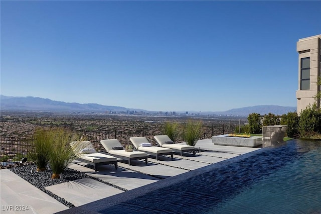 view of patio / terrace with fence and a mountain view