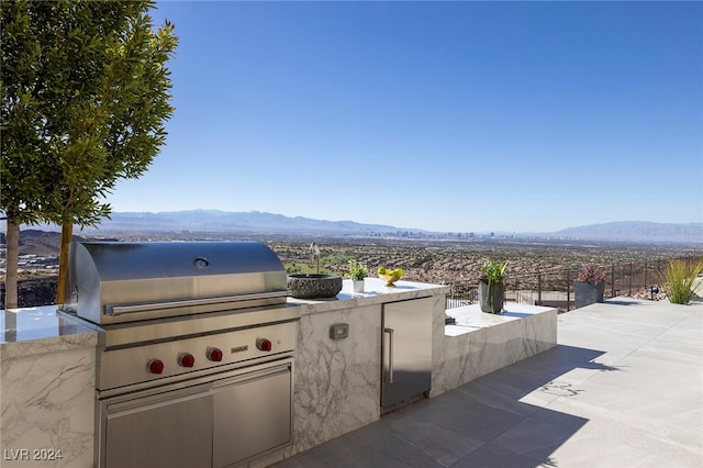 view of patio with a mountain view and area for grilling