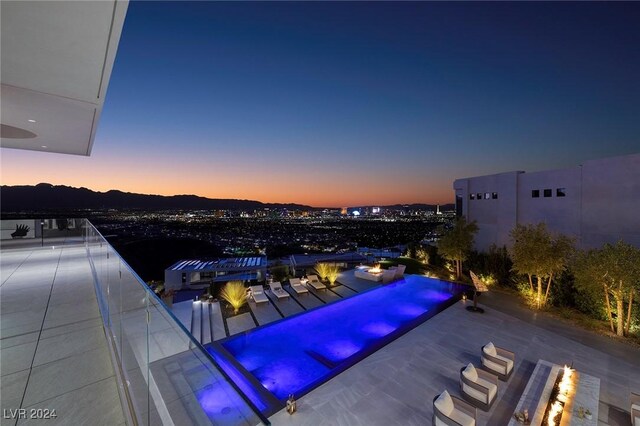 pool at dusk featuring a mountain view