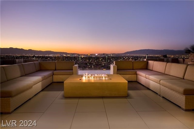 patio terrace at dusk featuring an outdoor living space and a mountain view