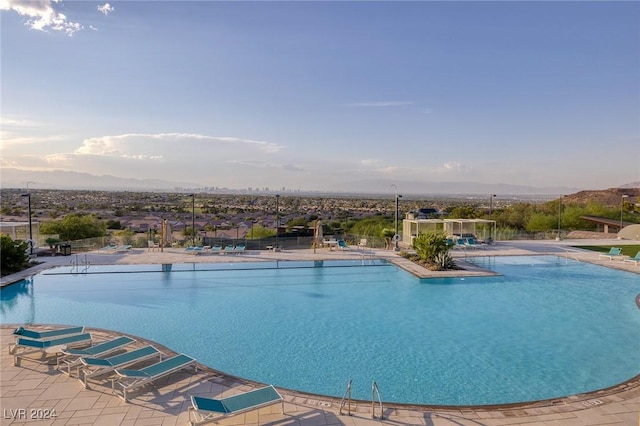 community pool with a water slide and a patio