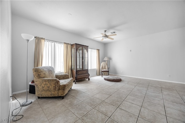 living area featuring ceiling fan and light tile patterned flooring