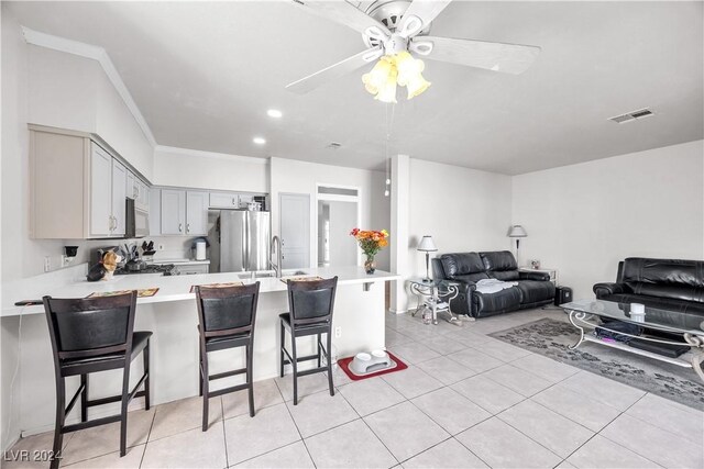 kitchen featuring gray cabinetry, a kitchen bar, ceiling fan, and kitchen peninsula