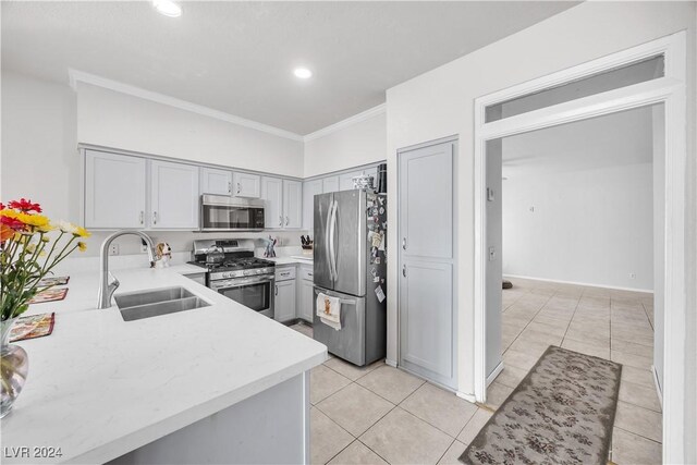 kitchen with ornamental molding, appliances with stainless steel finishes, sink, and gray cabinetry