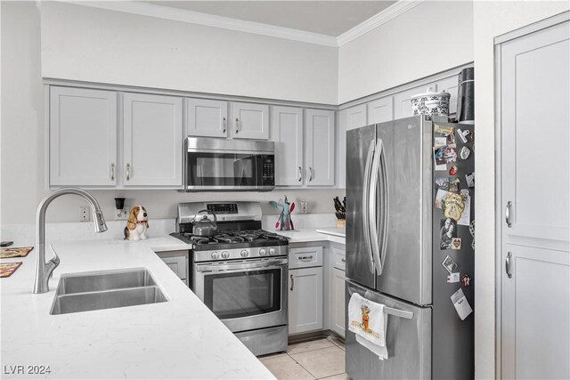 kitchen featuring light tile patterned flooring, sink, gray cabinetry, stainless steel appliances, and crown molding