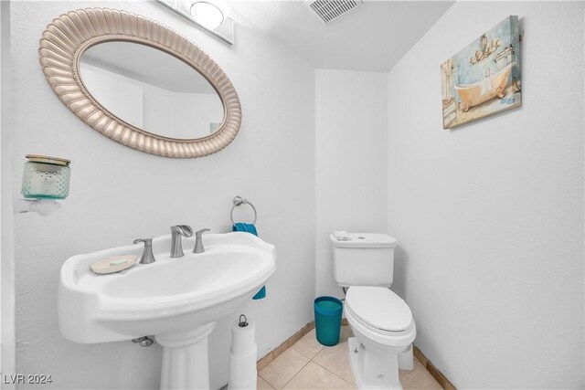 bathroom featuring sink, toilet, and tile patterned floors