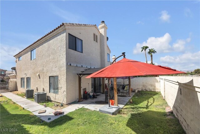 back of house with a patio, a yard, and central AC unit