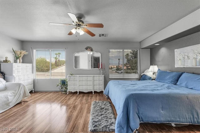 bedroom featuring a textured ceiling, hardwood / wood-style flooring, and ceiling fan