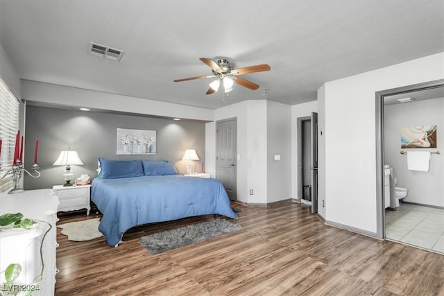 bedroom with ceiling fan, ensuite bath, and light wood-type flooring