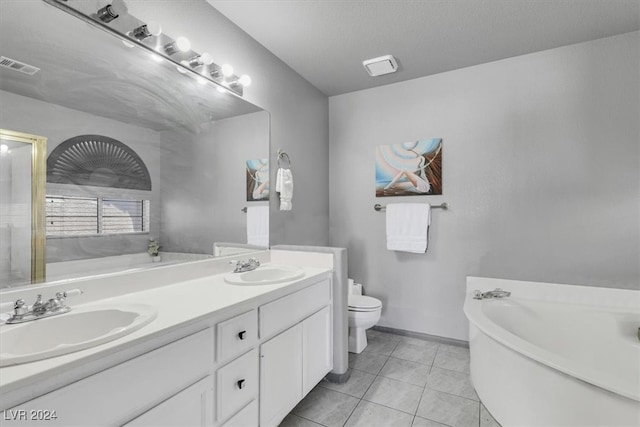 bathroom featuring tile patterned flooring, vanity, toilet, and a washtub