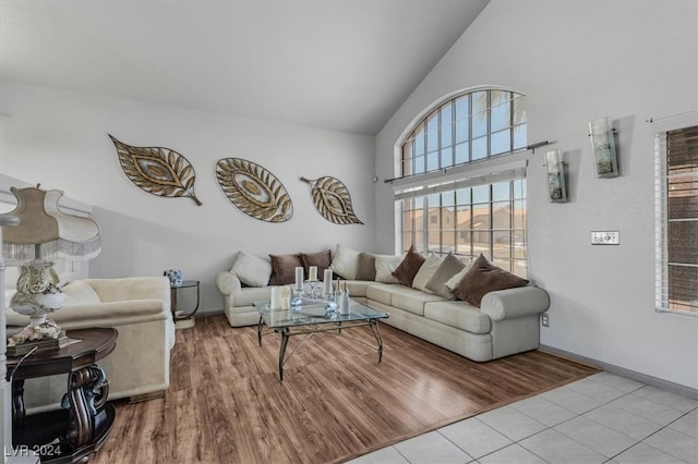 living room with light tile patterned floors and high vaulted ceiling