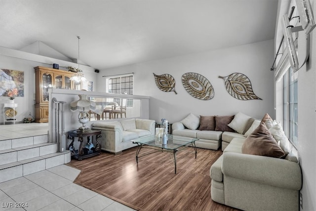 living room with high vaulted ceiling, plenty of natural light, and light hardwood / wood-style flooring