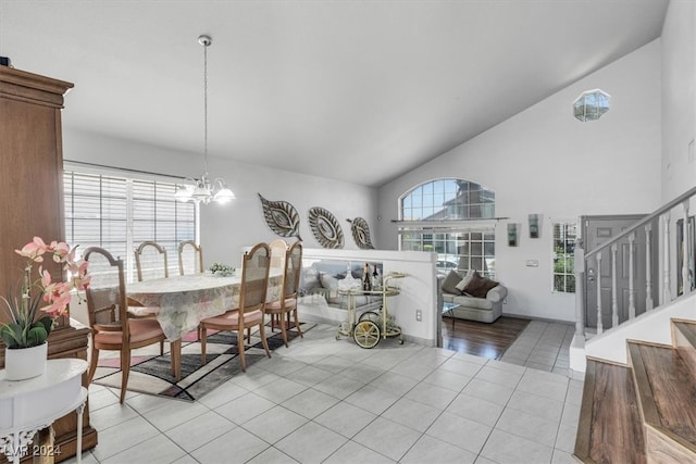 dining space with high vaulted ceiling, a chandelier, and light tile patterned flooring