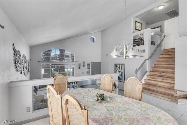 tiled dining space featuring vaulted ceiling and a chandelier