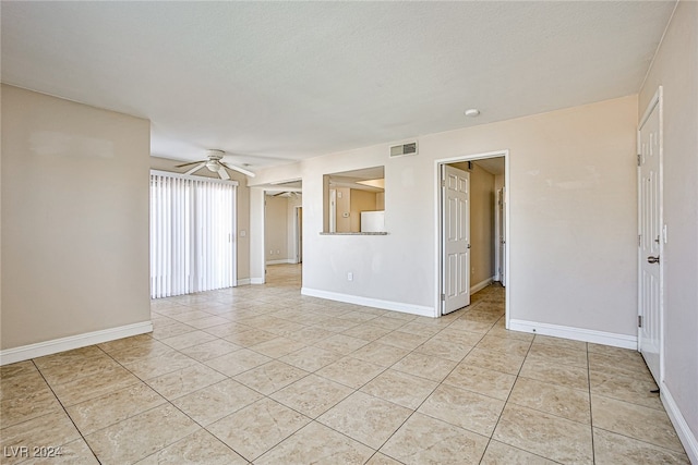 spare room featuring ceiling fan and light tile patterned floors