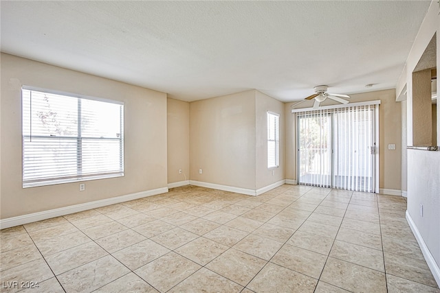 spare room with ceiling fan, light tile patterned floors, and a textured ceiling